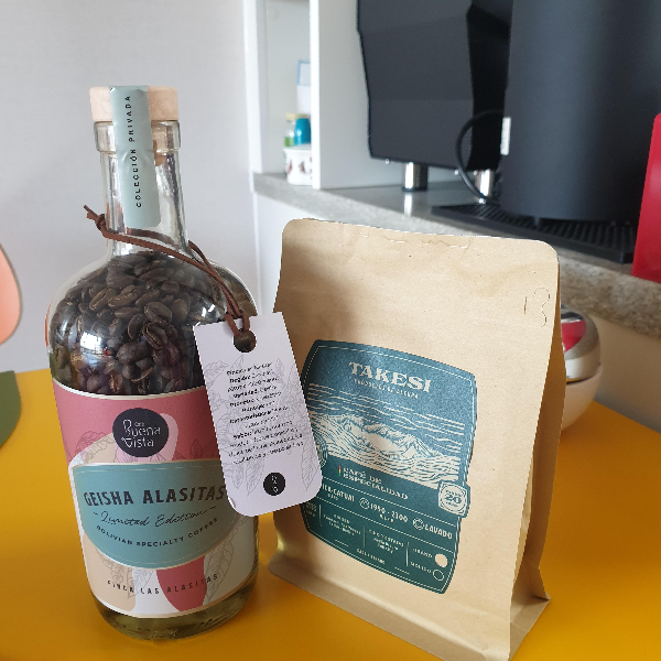 병에 게이샤 원두가 들어있고 종이 패키지에 다른 원두가 있다.