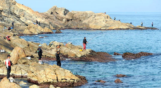 갯바위마다 낚시하고 있는 낚시꾼들 모습
