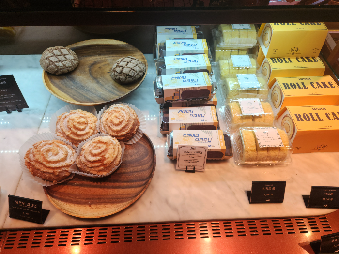 A tortoise shell-shaped chocolate bun and coconut milk bun are on a plate.