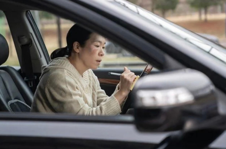 자동차 안에서 메모하고 있는 염혜란