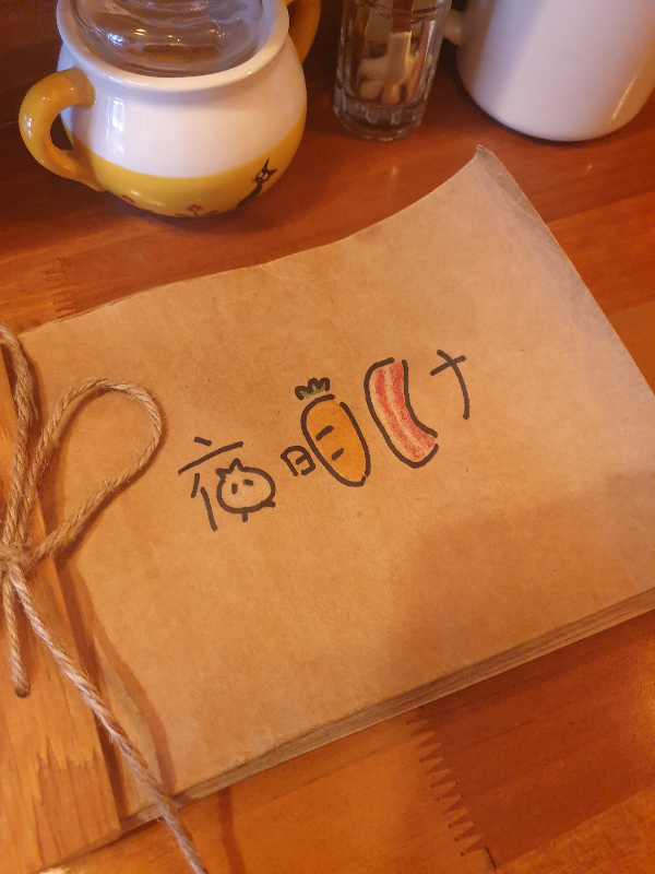 테이블 위에 메뉴판이 놓여있다. 돼지, 당근, 양파 등의 그림으로 일본어로 표지가 되어 있다.