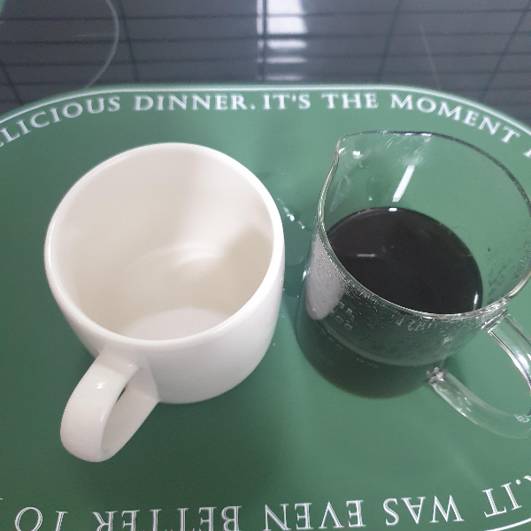 왼쪽 컵은 비어있고 오른쪽 서버는 추출된 커피가 담겨있다.