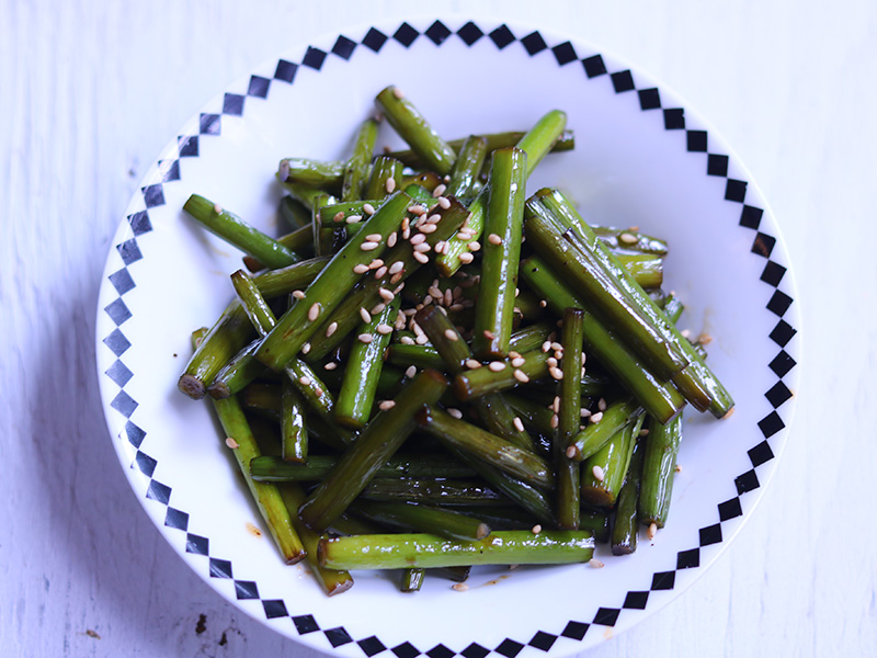 흰접시에 담은 깨 뿌린 마늘쫑