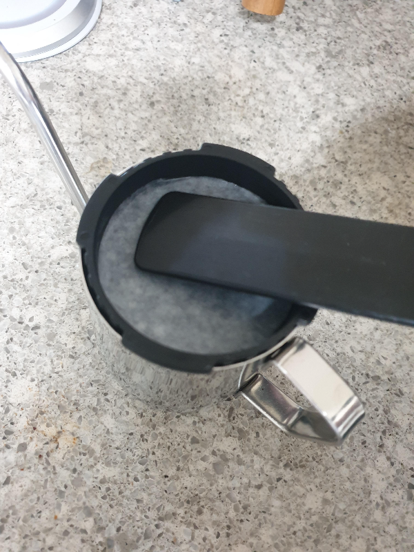 드립포트에 에어로프레스 캡을 올려놓고 린싱하는 모습. 필터를 캡에 밀착시키는 중이다.