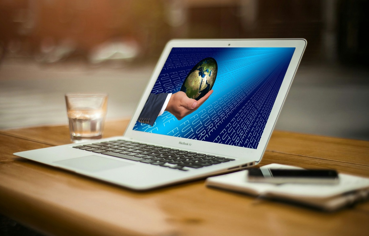 지구본을 든 손 화면이 띄워진 노트북