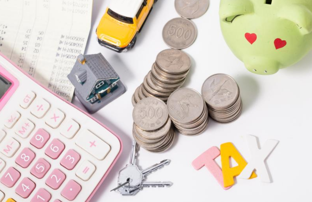 오백원짜리 동전이 수북히 쌓여 있고 계산기와 열쇠가 놓여있다.