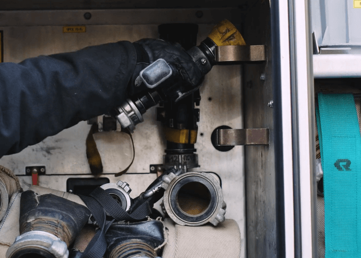 분리되어 있는 소방 호스를 꺼내는 사람