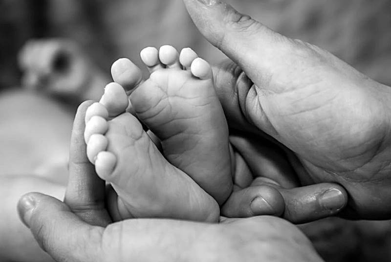 갓난-아기의-발을-만지는-부모의-모습