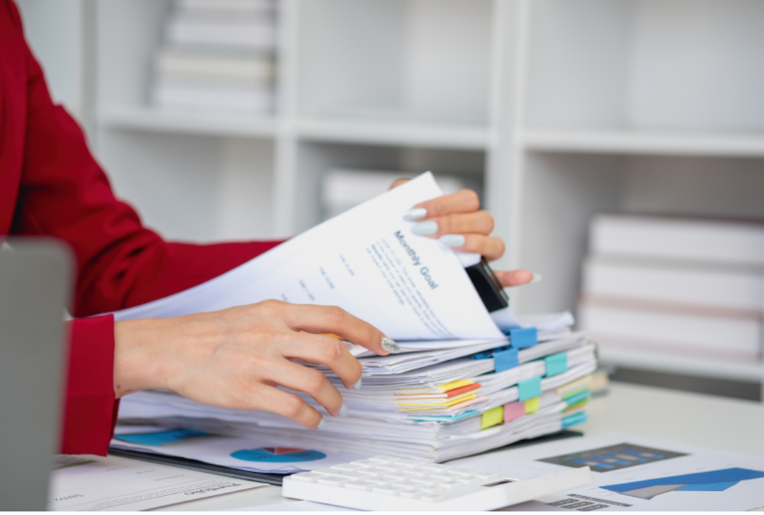 한 여성의 수많은 서류들을 보고 있다.