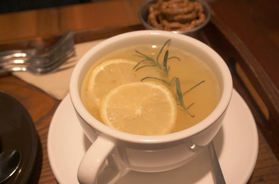 찻잔에 차와 레몬 슬라이스가 들어있다.