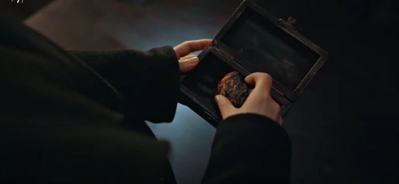 오래된 상자에서 낡고 작으면서 타원형의 물건을 집고 있는 구산영