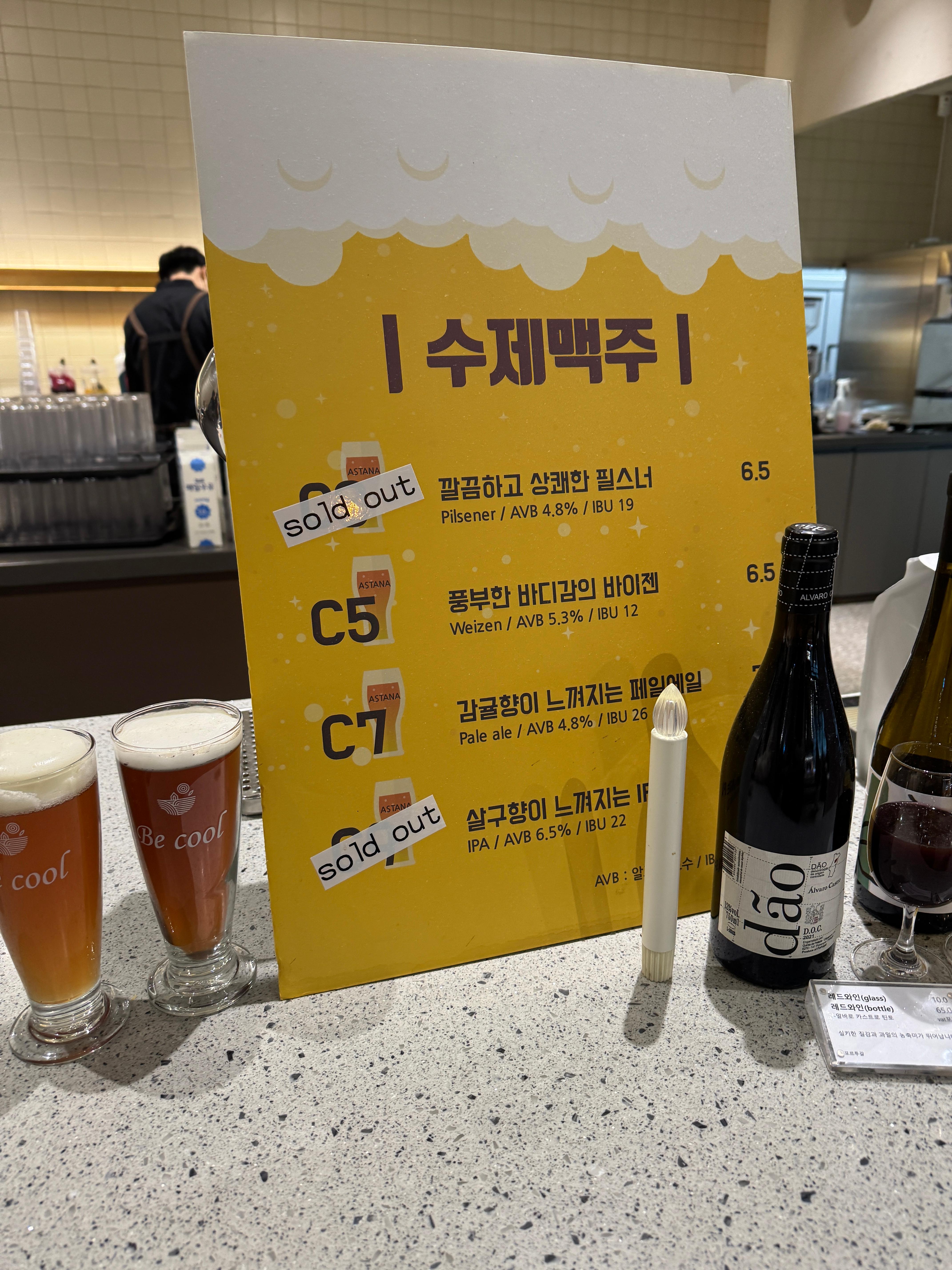 동탄 카페 아스타나 수제맥주 메뉴, 필스너&middot;바이젠&middot;페일에일&middot;IPA 등 수제맥주 종류와 sold out 표시가 있는 맥주 메뉴판과 맥주 잔 진열