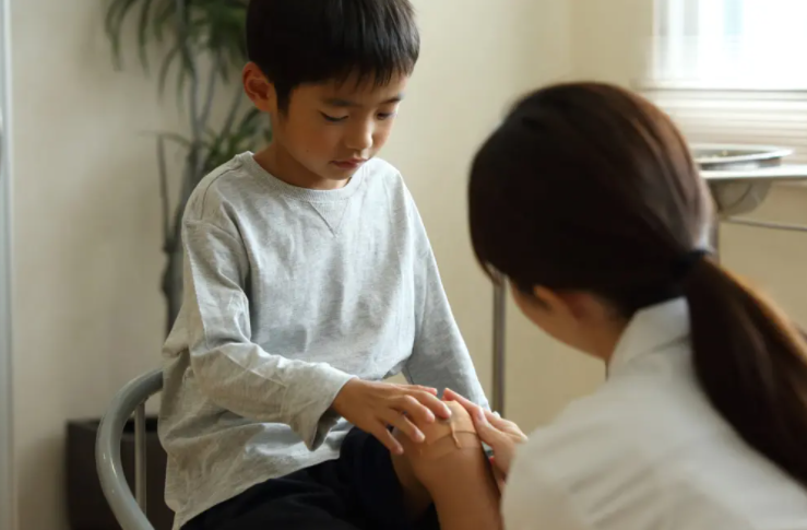 타박상을 진료 받는 소년과 의사선생님