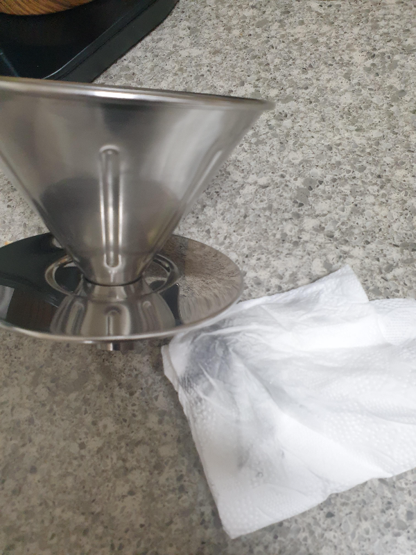 드리퍼와 드리퍼 연마제를 닦아낸 키친타월. 키친타올에 검은 때가 선명히 보인다.