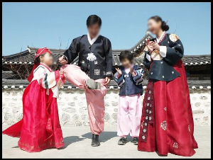 한복입은 네명 가족 제기차기 하며 즐거워함