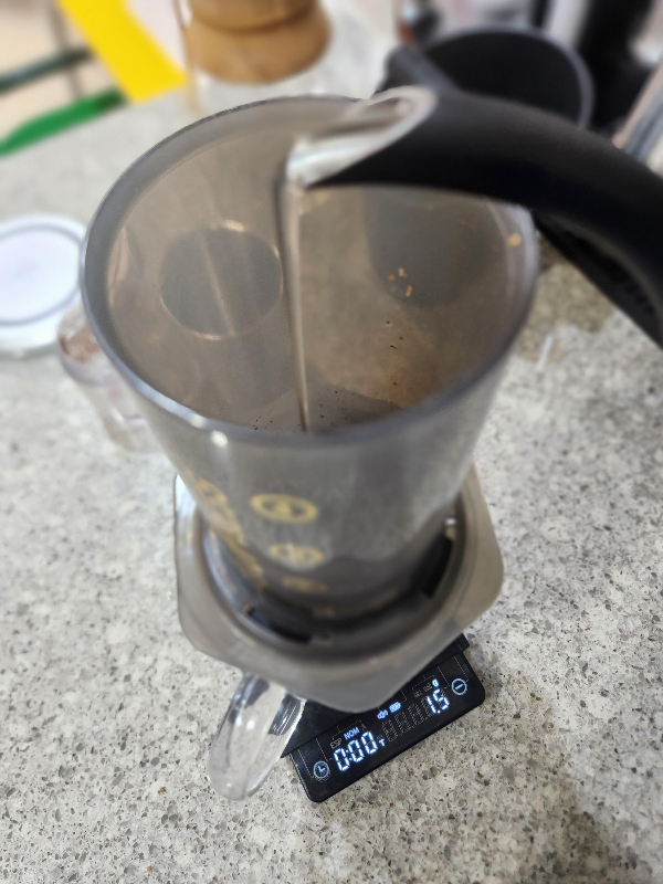 캡을 결합한 에어로프레스에 커피를 넣고 물을 붓는 모습