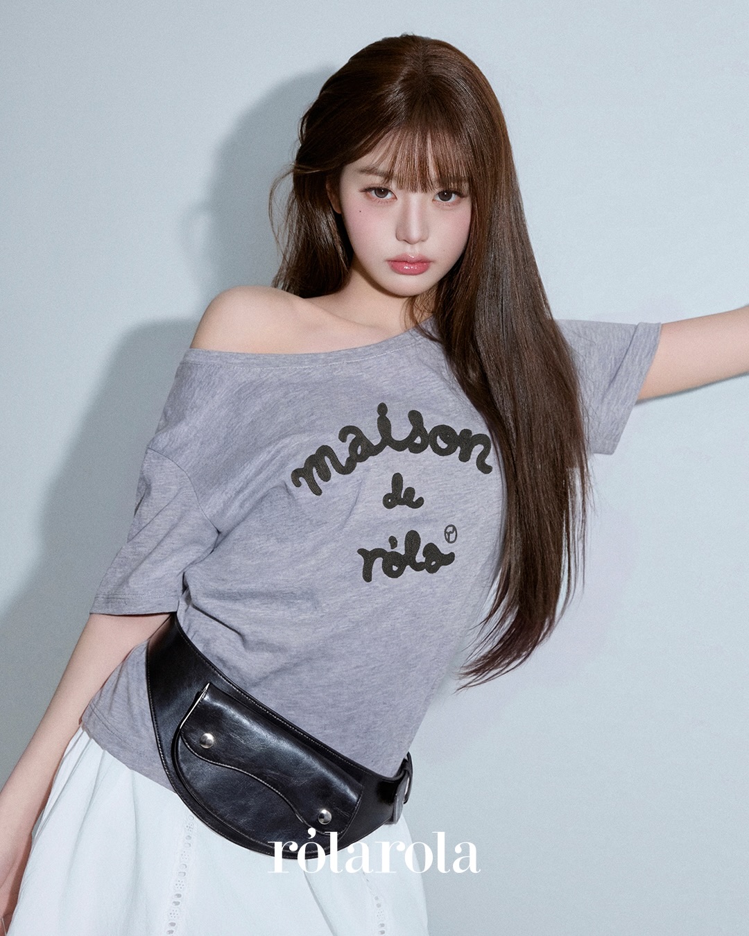허리에 힙색을 두르고 흰 스커트를 입고, 로라로라 반팔을 입은 장원영의 모습