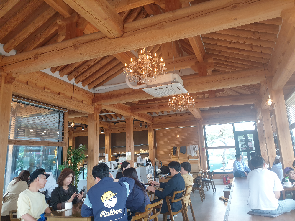 카페 내부 한옥 석가래 등을 인테리어 포인트로 잡은 창가는 좌식 평상