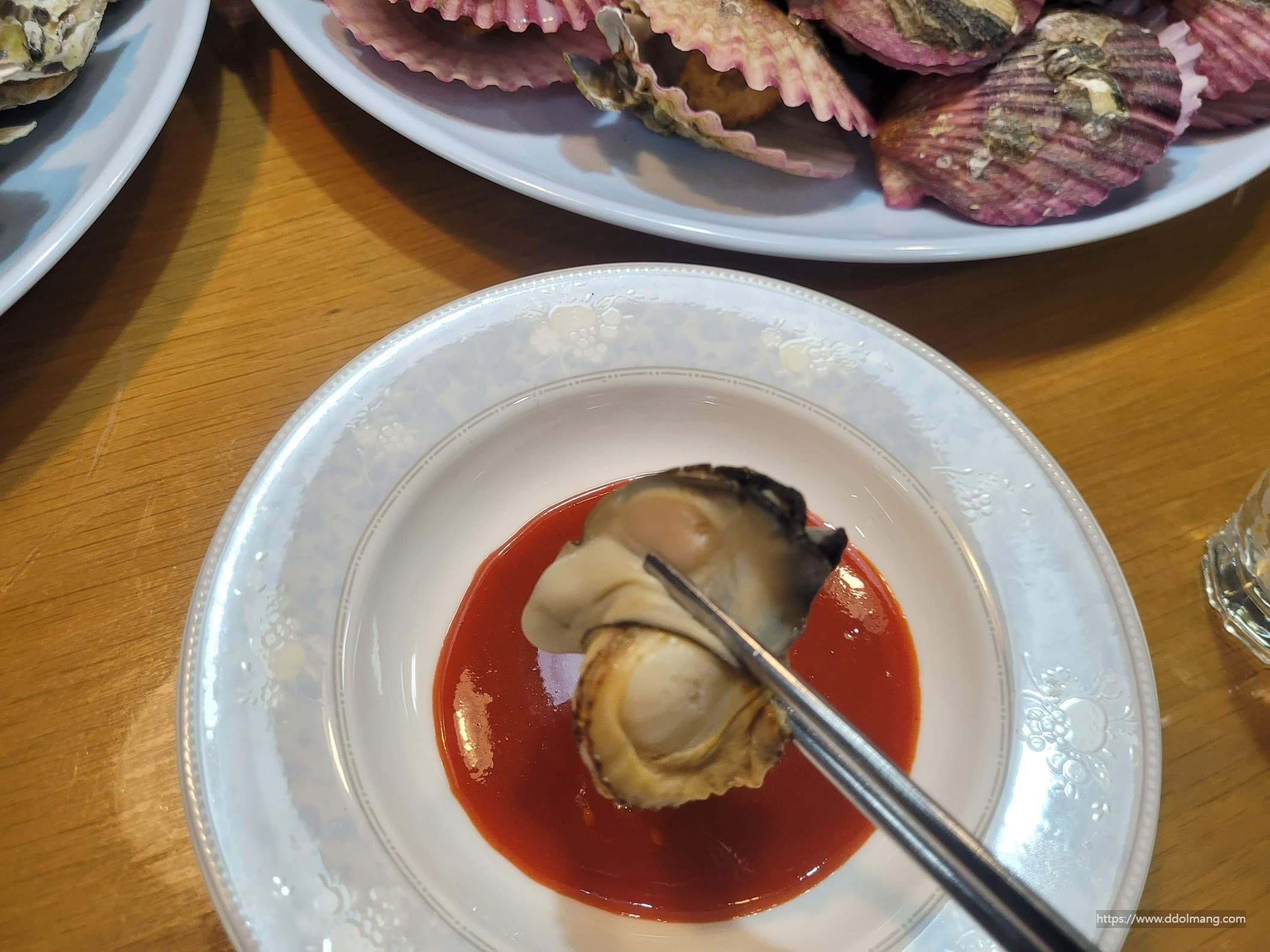 굴과 가리비를 초장에 찍는 모습