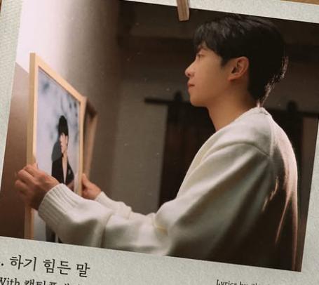 이승기가-액자를-벽에-걸고있다.