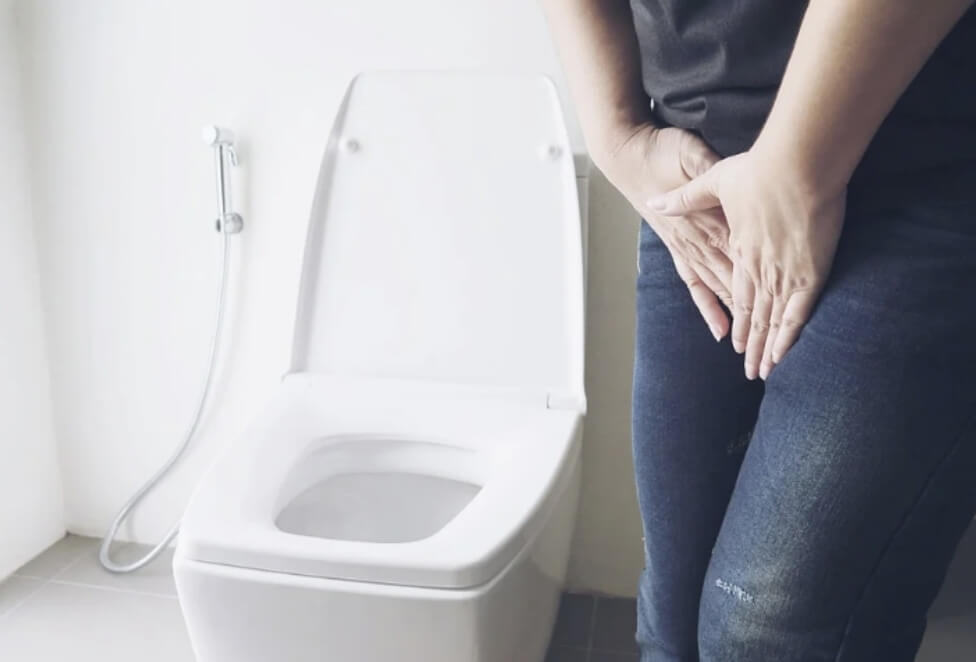 변기 앞에서 소변이 마려운 포즈를 하고 있다