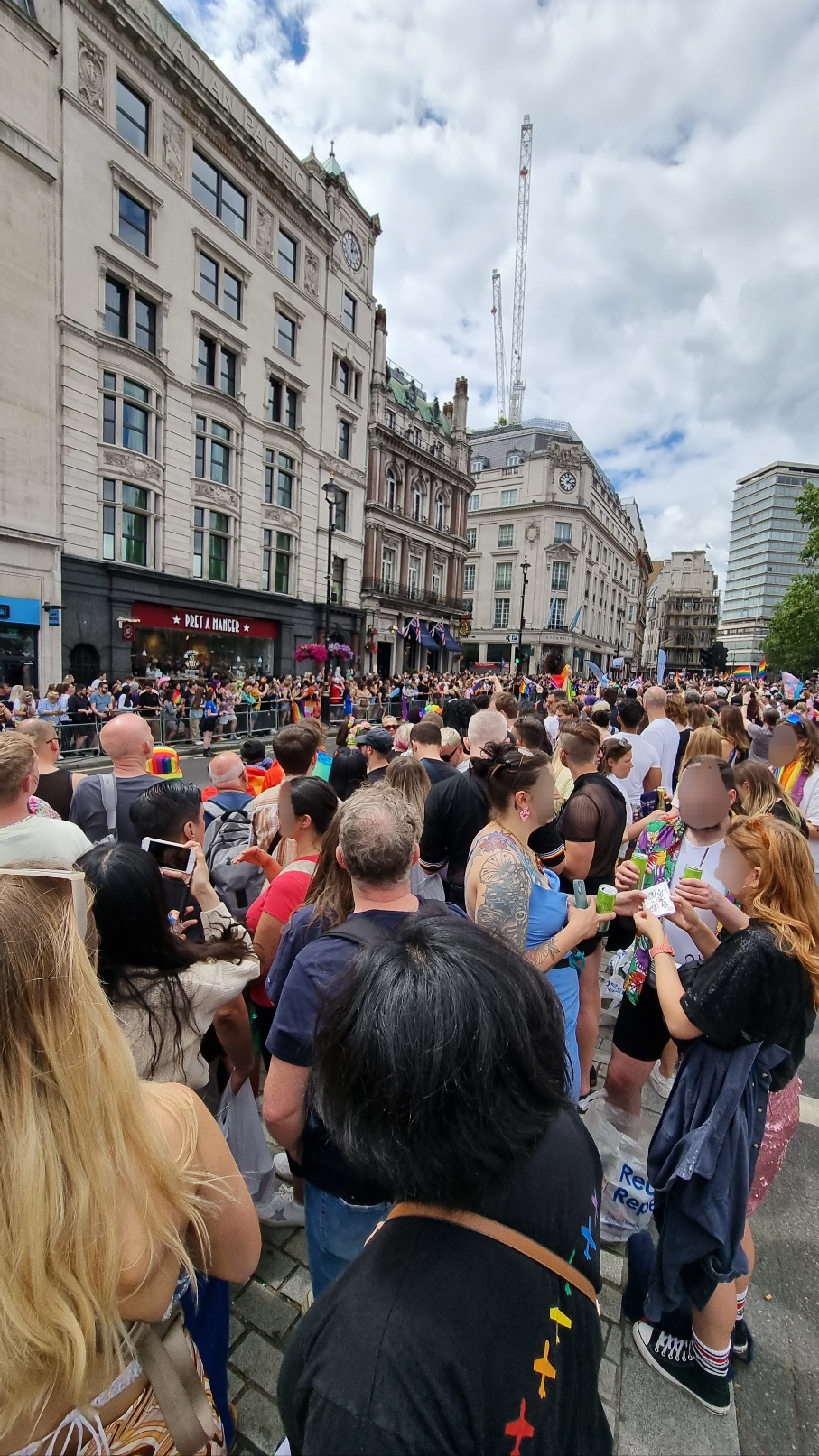 런던 퀴어 퍼레이드를 기다리는 많은 사람들. 하얀 구름 사이로 푸른 하늘이 조금씩 보이고&amp;#44; 빨주노초파남보 비행기가 등에 그려진 검은 티셔츠를 입은 작성자가 중앙 하단에 서있다.