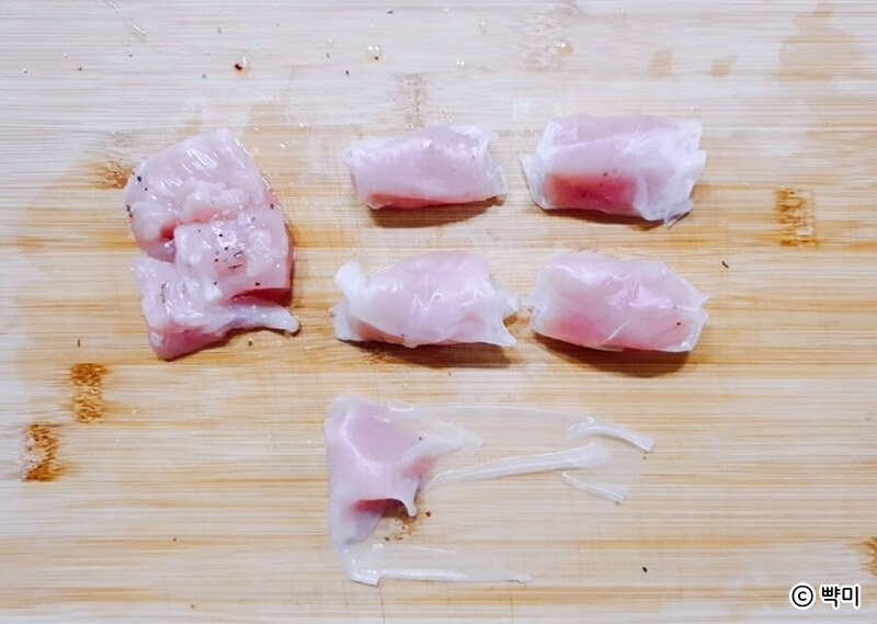 라이스페이퍼에 물을 적셔 펼친 후 닭가슴살을 올리는 장면