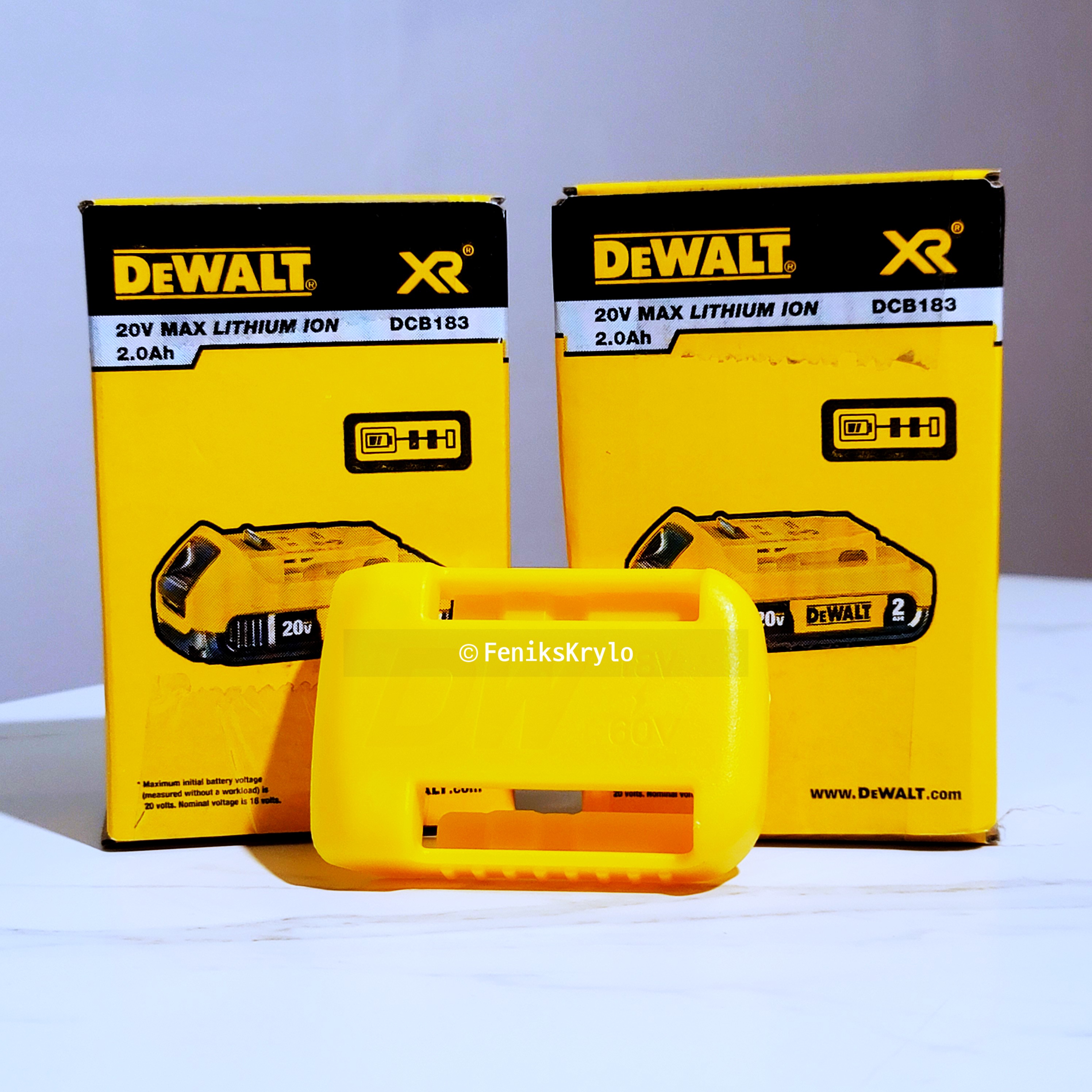 디월트-배터리-20V-두개와-보호커퍼가-테이블-위에-놓여있다.