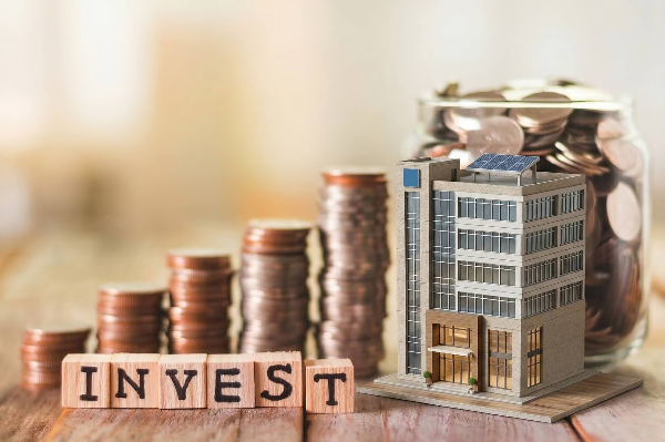 INVEST 글자 블록 옆에 차례대로 쌓여 있는 동전 탑을 통해 채권 ETF 투자를 표현한 모습