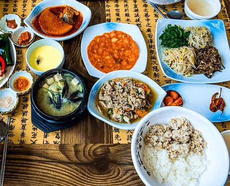 식탁 위에 나물 반찬들과 보리밥, 된장국이 있다.