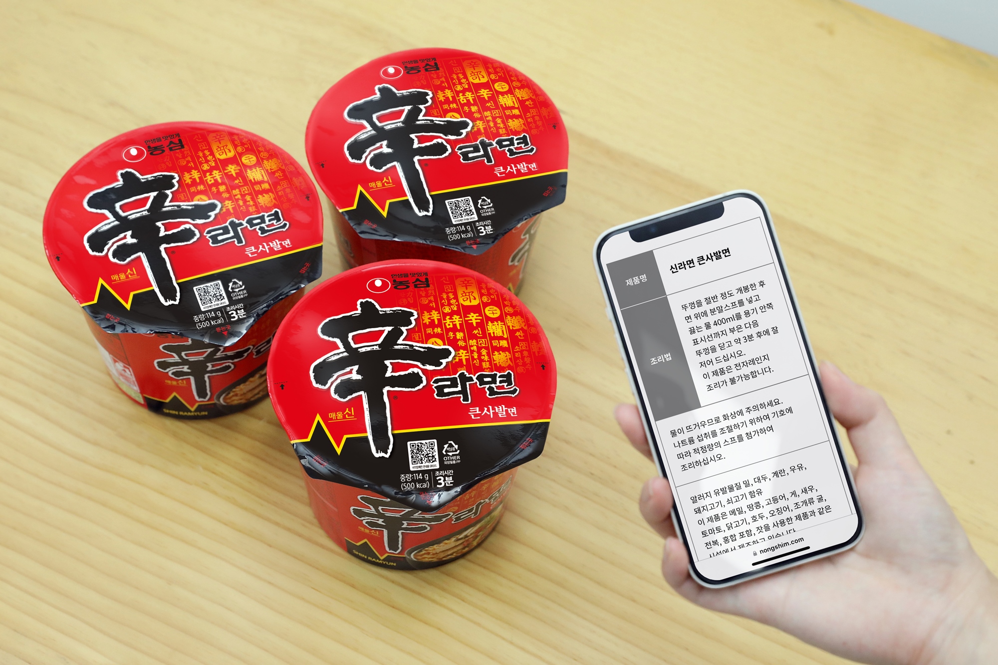 농심 신라면 큰사발에 삽입된 QR코드를 핸드폰을 사용하여 읽고 있다. 핸드폰 화면에는 제품명과 조리법등이 설명되어있음.