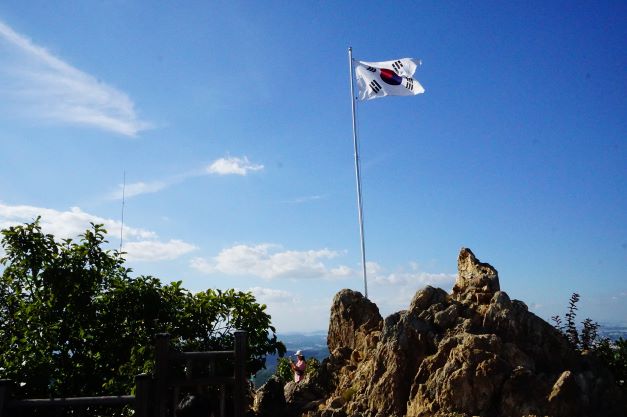 정상 바위에 펄럭이는 태극기, 푸른 하늘,