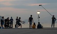 으스름한-날씨에-조명을-켜고-스태프들이-지켜보는-가운데-배우들이-연기를-시작하며-슬레이트를-치는-순간