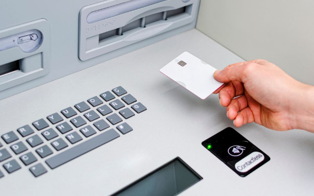 ATM기에 카드를 넣고 있는 모습.