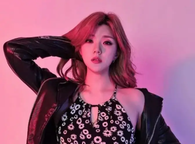 김수현- 빨간배경 앞 검은 쟈켓 검은 원피스를 입고 서있는 김주나