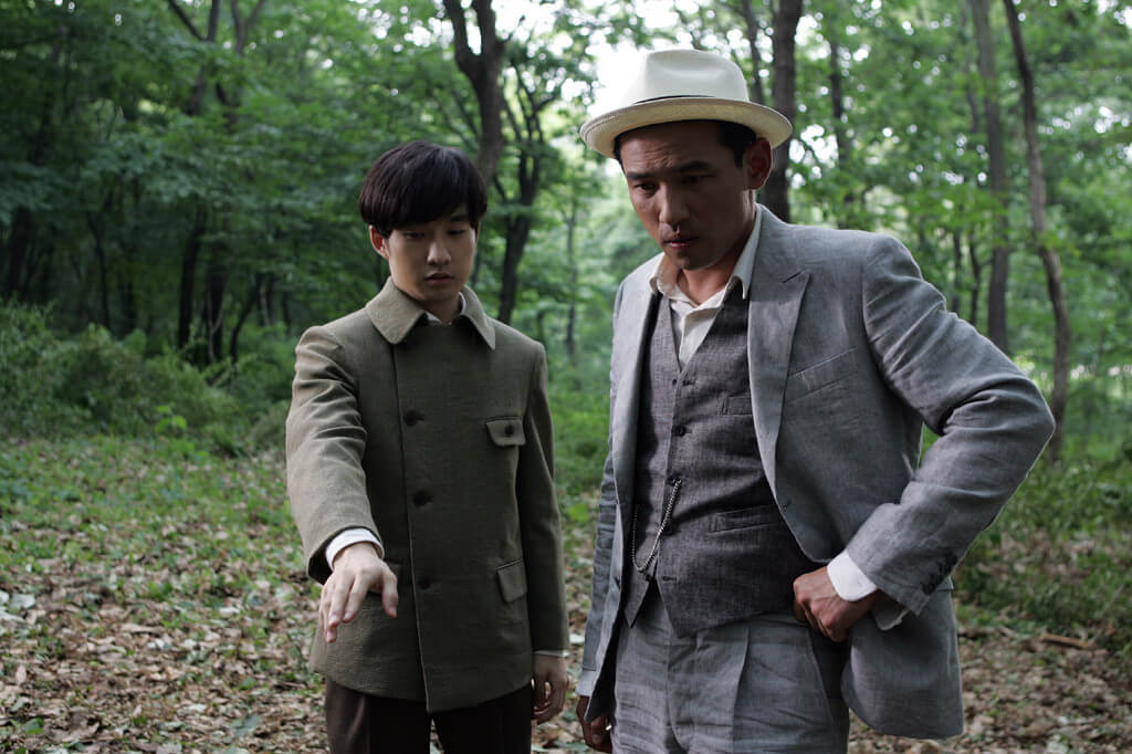 광수와 진호가 민수현의 시체가 있던 자리를 손으로 가리키며 응시하는 모습