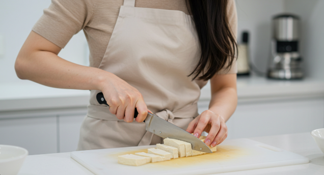 깨끗한 도마 위에 두부를 1.5cm 두께로 가지런히 썰고 있는 모습