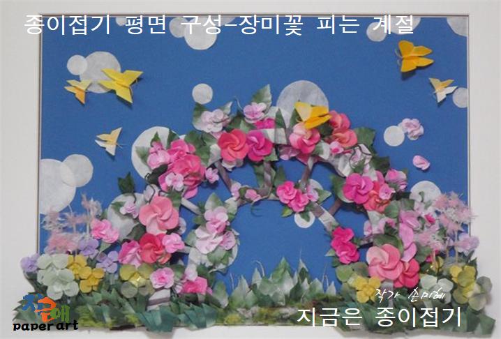 핑크색의 장미꽃 넝쿨이 아치형 울타리에 만개한 모양의 종이접기 구성 작품입니다.