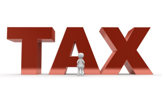 거대한 TAX 글자 앞에 서 있는 사람 모형