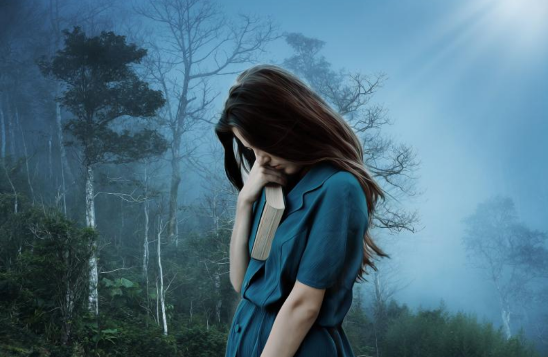 숲 속 한 가운데 우울한 듯 고개를 푹 숙인 여성