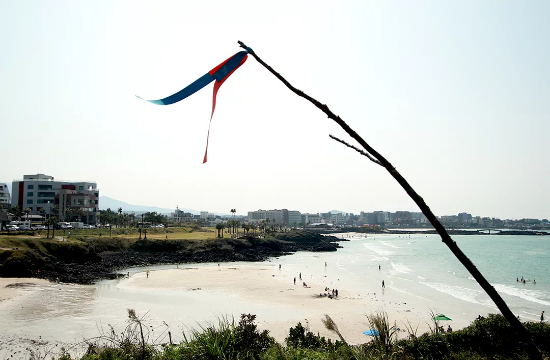 서우봉 오르막길에서 올레 리본 너머로 바라본 함덕해수욕장 전경 사진.