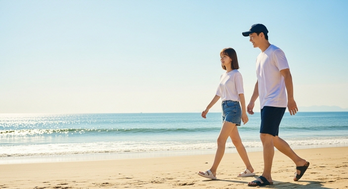 여름철 산뜻한 샌들을 신고 해변 산책하는 한국인 모습