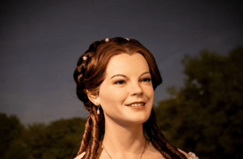 아름다운 여왕이 저녁에 야외에서 누군가와 대화를 하는 모습이고 해맑게 웃고 있습니다.