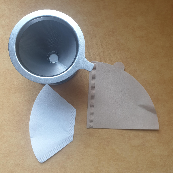 노란색 바닥에 세 개의 드리퍼 위쪽에 메탈 드리퍼 아래 왼쪽 흰색 필터 우측 노란색 종이 필터가 위치