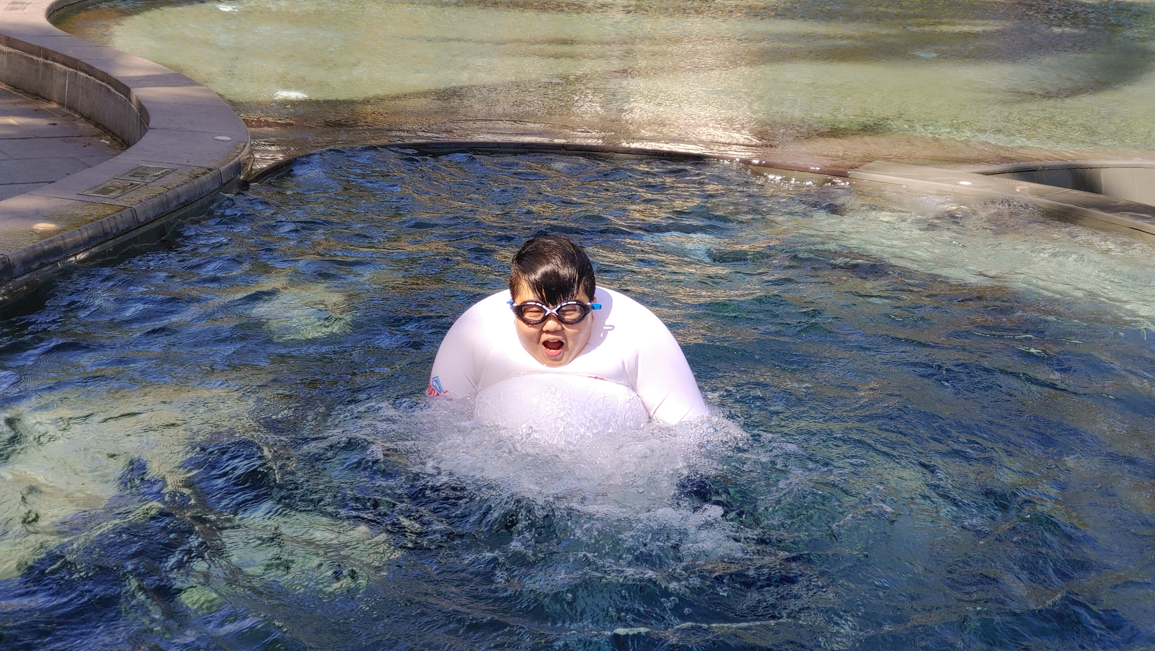 수영장에서 옷을 부풀리며 노는 소년