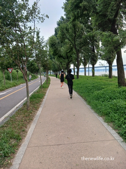 강변 산책로에서 보폭을 줄여 슬로우 조깅을 하는 남성