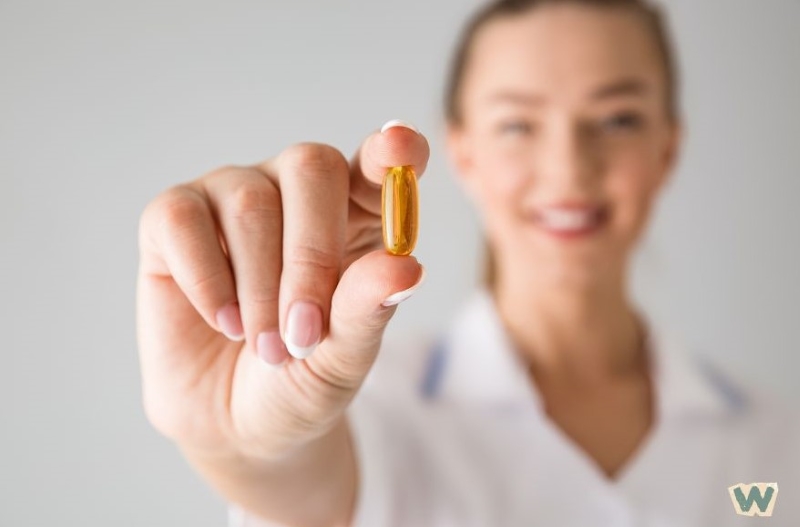 의료진이 오메가3 비타민 캡슐을 손에 들고 영양제 효과를 설명하는 모습 via canva