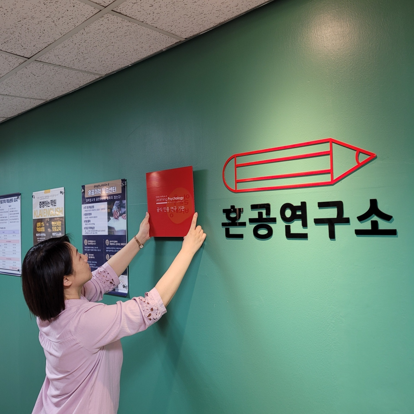 혼공연구수 오경란대표가 한국학습심리연구소와의 협업 현판을 입구 벽면에 게시하고 있습니다.
