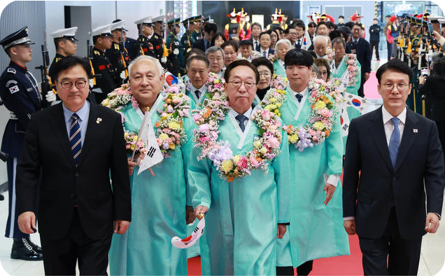 23일 서울 강서구 김포공항 국제선 청사 입국장에서 열린 &lsquo;대한민국임시정부 요인 환국 재현&rsquo; 행사에서 임시정부 요인 후손들이 김민석 국무총리, 우원식 국회의장과 함께 도열한 의장대를 사열하며 입장하고 있다. [사진=연합뉴스]