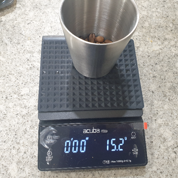 저울 위 컵에 원두가 담겨 있다. 저울은 15g을 가르킨다.